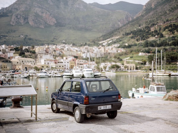 Fiat Panda I (1980-2003) vor der Kulisse von Castellamare del Golfo mit einem anonymisierten Kennzeichen aus dem Zeitraum 1994 bis 1999. Die beiden ersten Buchstaben sind nicht wie bei den Vorgängern Hinweis auf die Provinz. Seit 1999 haben die Italiener mit Einführung der Euro-Kennzeichen wieder die Möglichkeit, das Provinzkürzel auf den Schildern einzutragen.